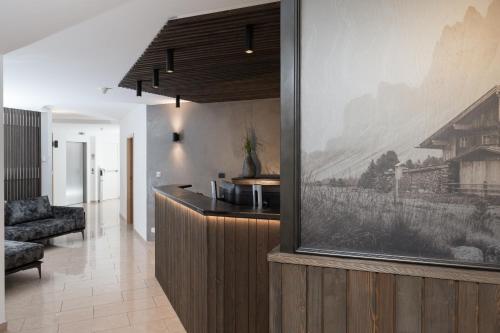 a kitchen with a large painting on the wall at Aparthotel Familiaris - Family Apartments - Pools & Spa in Dolomites in Valdaora