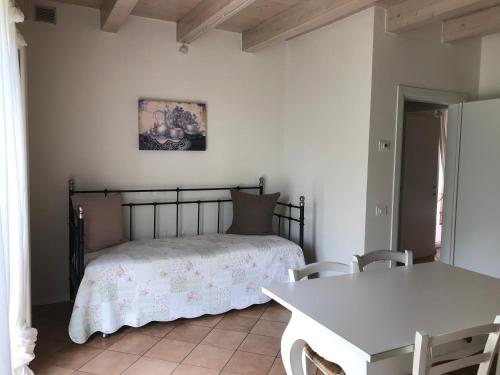 a bedroom with a bed and a table with chairs at Agriturismo Maso Bergot in Arco