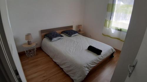 a small bedroom with a bed with a black bag on it at Maison entière moderne tout confort de 92m² in Angoulême