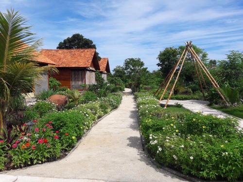 a garden with a path leading to a house at Marind Dive Eco Resort in Waha