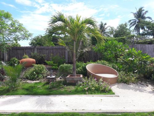 a palm tree in a garden next to a fence at Marind Dive Eco Resort in Waha