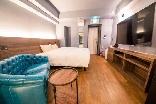 a hotel room with a bed and a couch and a tv at Hotel Brick in Naha