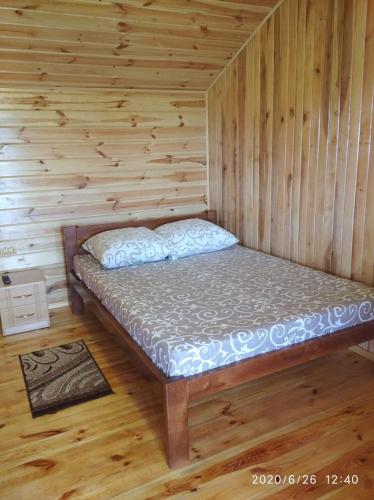 a room with a bed in a wooden cabin at Цвіт лілії in Szack