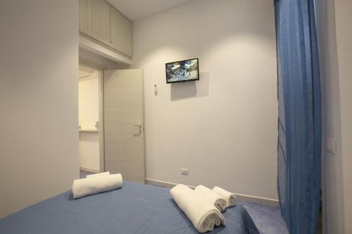 a bedroom with a bed and a tv on the wall at Al Baglio in Castellammare del Golfo