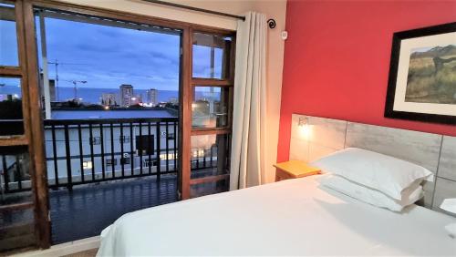 a bedroom with a bed and a large window at Crooked Tree Cottage in Durban