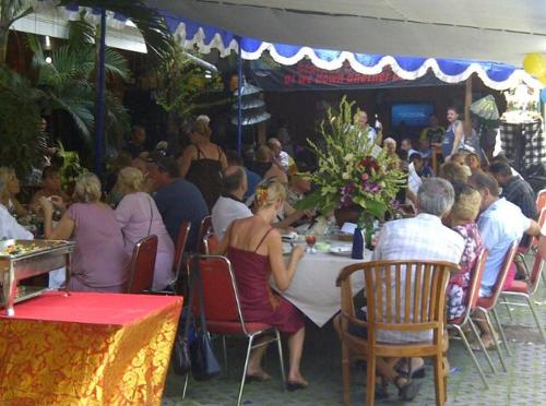 un grupo de personas sentadas en una mesa en un restaurante en Bali Senia Hotel, en Sanur