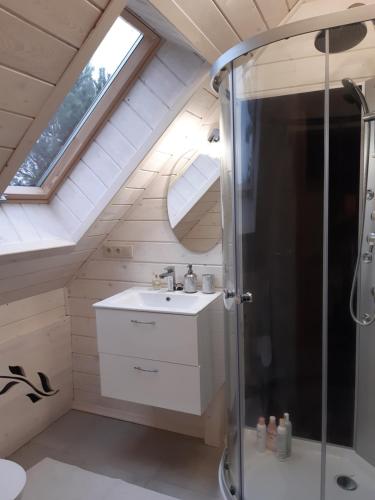 a bathroom with a sink and a shower in a attic at Pasym Willa Ślimakowo in Pasym