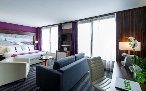 Habitación de hotel con sofá y cama en Holiday Inn Toulouse Airport, an IHG Hotel en Blagnac
