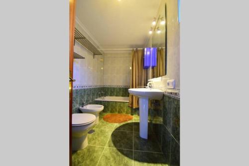a bathroom with a sink and a toilet and a tub at Apartamento Loft in Navia