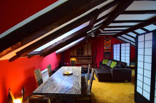 a living room with a wooden table and red walls at Apartamento Loft in Navia