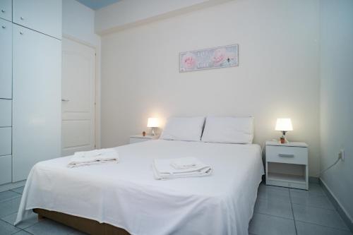 a white bedroom with a large bed with white sheets at Villa Georgia in Vasilikos