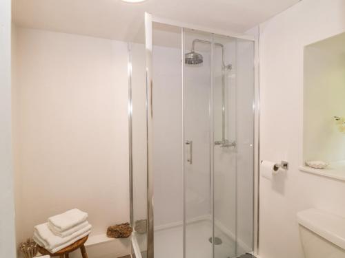 a white bathroom with a shower and a sink at The Barn in Dalbeattie