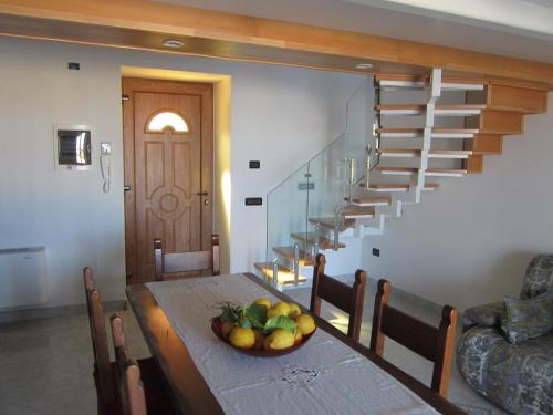 ein Esszimmer mit einem Tisch und einer Obstschale darauf in der Unterkunft Villa Flora Ischia in Ischia