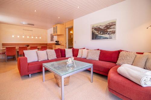 uma sala de estar com um sofá vermelho e uma mesa em Sans Souci EG em Arosa