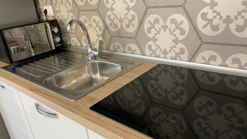a stainless steel sink in a kitchen with a wall at Mazzitelli Apartment in Capo Vaticano