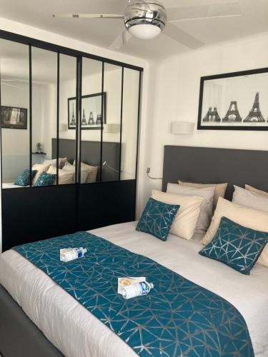 una camera da letto con un grande letto con cuscini blu e bianchi di Cannes City B&B a Cannes