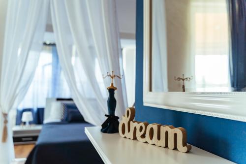 Sunrise Hotel في بريمورسكو: غرفة مع سرير مع مرآة و مزهرية على طاولة