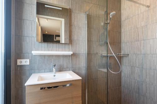 een badkamer met wastafel en douche bij BizStay Maurits in Den Haag