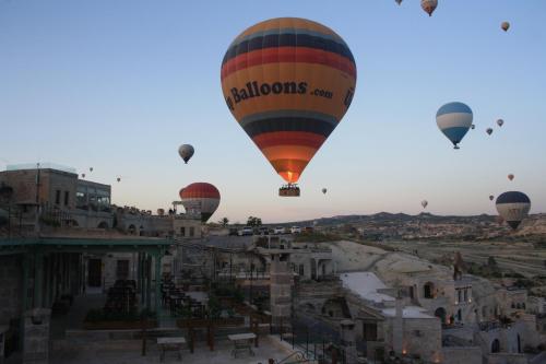 a group of hot air balloons flying over a city at Seki Cave Suites in Goreme