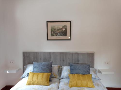 een bed met gele en blauwe kussens erop bij Easo Terrace Apartment free private parking and air conditioning in San Sebastian