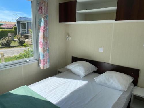 une chambre avec un lit blanc et une fenêtre dans l'établissement Camping-Caravaning de la Mollière, à Groffliers