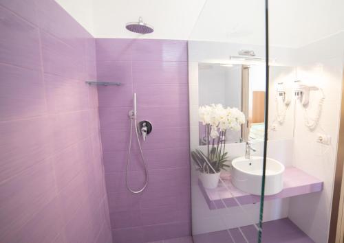 Un baño morado con lavabo y ducha. en Residence Paradise, en Peschici
