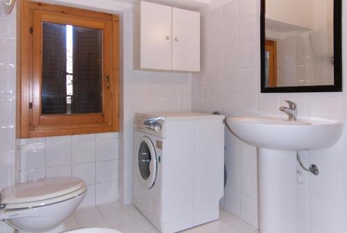 biała łazienka z umywalką i pralką w obiekcie Nice Assisi w Asyżu