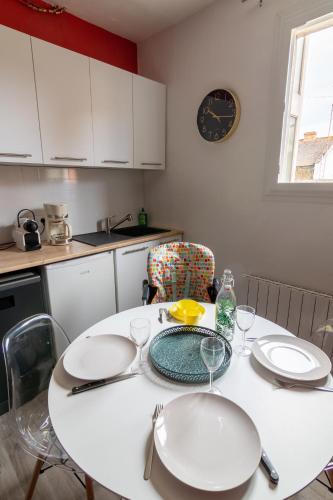 une cuisine avec une table avec des assiettes et des verres dessus dans l'établissement DUPLEX LE SAINT JEAN, à Saumur