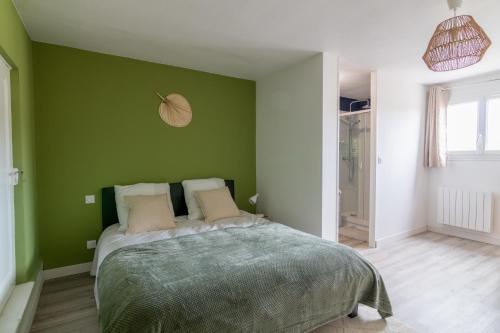Un dormitorio con una pared verde y una cama en DUPLEX LE SAINT JEAN, en Saumur