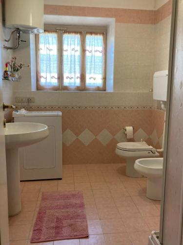 a bathroom with a sink and a toilet and a window at Casa Milanda in Gargnano