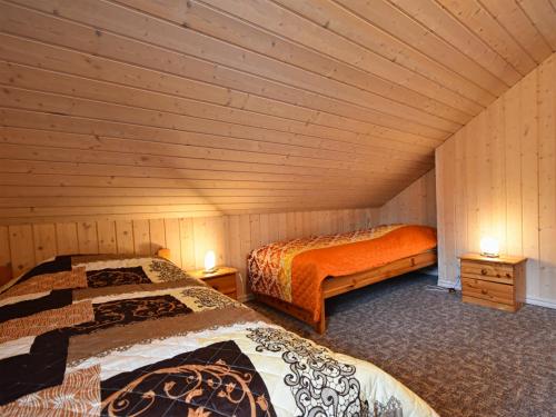 two beds in a room with wooden walls at Ferienhaus Ostseeblick 274 in Baabe
