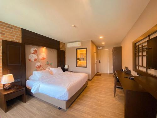 a bedroom with a large bed and a television at River Tree Resort in Chiang Khan