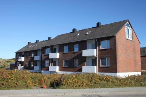 ein großes Backsteingebäude an der Straßenseite in der Unterkunft Leuchtturm in Hörnum