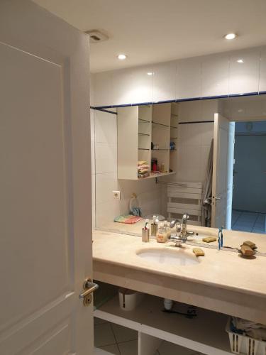 - une cuisine avec un évier et un grand miroir dans l'établissement 2 chambres et canapé lit bureau - Marina Plage - Agréable, à Hendaye