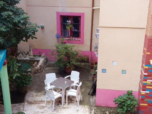 a table and chairs in front of a pink house at Hosteria Picos De Europa in Potes