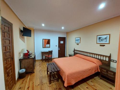 a bedroom with a bed and a table and a desk at Hosteria Picos De Europa in Potes