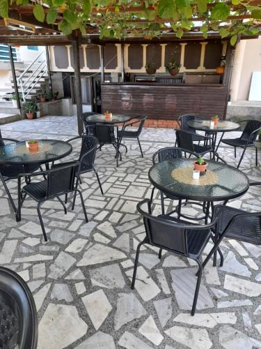 a patio with tables and chairs on a stone patio at BATO Rooms in Peštani