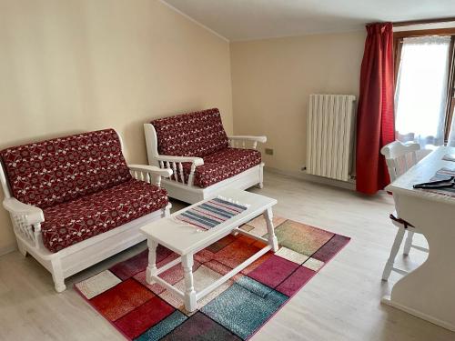 a living room with two chairs and a coffee table at Hotel Ristorante Combolo in Teglio