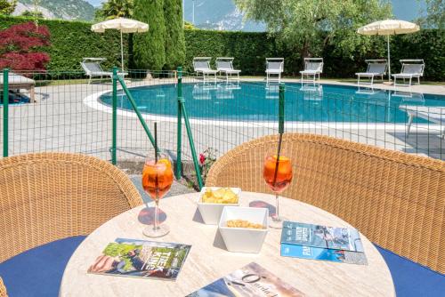 a table with drinks and food on it next to a pool at Residence Al Frantoio in Arco