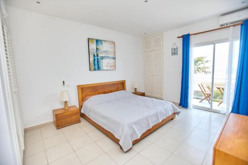 a bedroom with a bed and a large window at Appartement - Vue sur mer in Pointe-Noire
