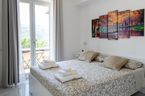 een witte slaapkamer met een bed met handdoeken erop bij A casa di Luca B&B in Torchiara