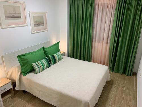 1 dormitorio con 1 cama con cortinas verdes en Valem, en Can Picafort