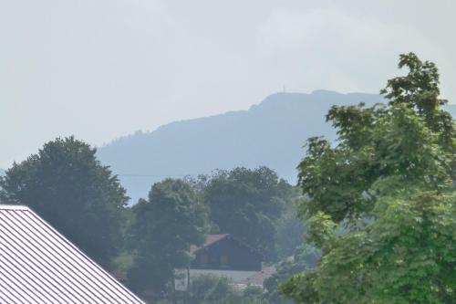 a view of a house in the midst of trees at Gîte Le Chasseron in Les Fourgs