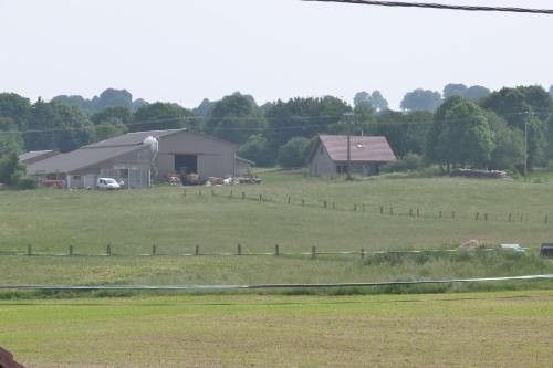 a large field with a house and a barn at Gîte Le Chasseron in Les Fourgs