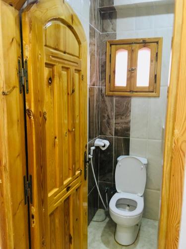 a bathroom with a toilet and a wooden door at Villa 22 in Dahab