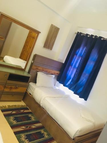 a bedroom with a bed with a blue curtain and a mirror at Villa 22 in Dahab