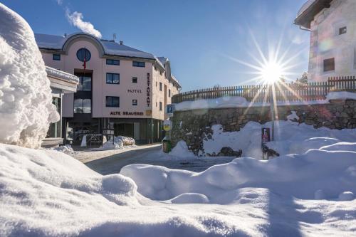 a city street covered in snow with a bus at Hotel Restaurant Alte Brauerei in Celerina