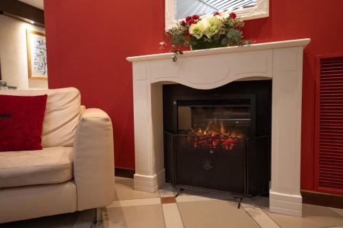 a living room with a fireplace and a couch at Boutique Hotel Re Enzo in Bologna