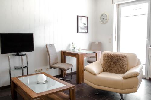 ein Wohnzimmer mit einem Stuhl und einem TV in der Unterkunft Gästehaus Edith, 4-Sterne für 2 Personen in Trittenheim