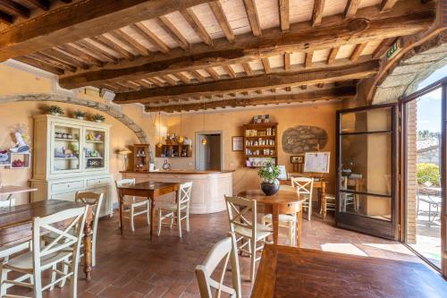 an open kitchen and dining room with wooden tables and chairs at La Melosa Resort & Spa in Roccastrada